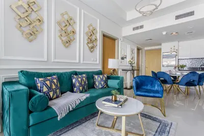 a living room with a green couch and blue chairs at Frank Porter - Aykon City Tower in Dubai