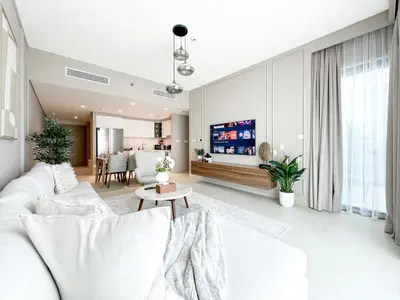 a living room with a white couch and a tv at Sky High Luxury 50th FLR Lux 2BDR Apartment in Downtown in Dubai