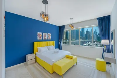 a blue bedroom with a yellow bed and a yellow chair at Full Sea View in Dubai Marina - Balcony & Pool in Dubai