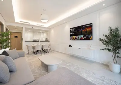 a living room with a couch and a tv on the wall at Bright High Floor Apartment in a 5 Star Hotel Resident Tower w Burj View and access to 64th Infinity Pool, Gym, Sauna, Spa, Restaurants, Bars and more in Dubai