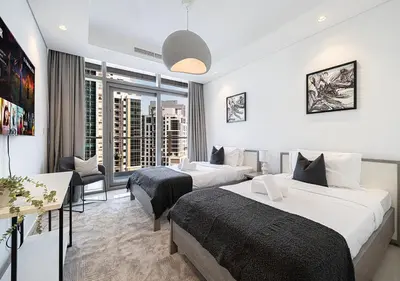 a hotel room with two beds and a window at Bright High Floor Apartment in a 5 Star Hotel Resident Tower w Burj View and access to 64th Infinity Pool, Gym, Sauna, Spa, Restaurants, Bars and more in Dubai