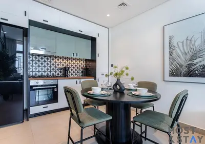 a kitchen and dining room with a table and chairs at Chic Urban 2BR at Collective 2 in Dubai