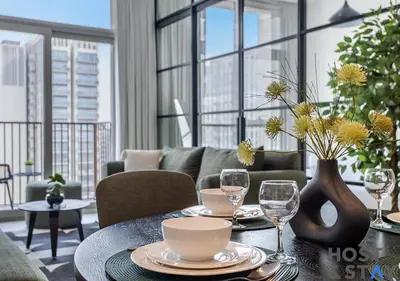 a living room with a table with plates and wine glasses at Chic Urban 2BR at Collective 2 in Dubai