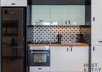 a kitchen with white cabinets and a stove top oven at Chic Urban 2BR at Collective 2 in Dubai