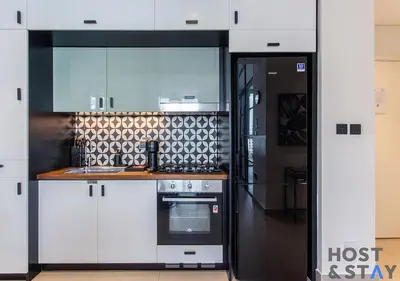 a kitchen with white cabinets and a stove at Upgraded 2BR In Dubai Hills in Dubai