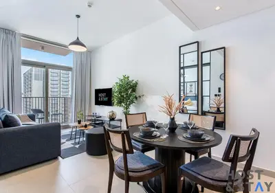 a living room with a table and chairs and a couch at Upgraded 2BR In Dubai Hills in Dubai