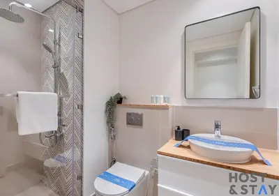 a bathroom with a toilet and a sink and a mirror at Modern 1bed Haven in Dubai Hills in Dubai
