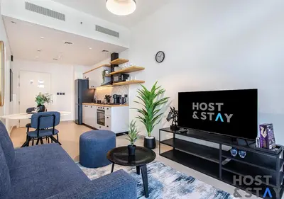 a living room with a couch and a tv at Modern 1bed Haven in Dubai Hills in Dubai