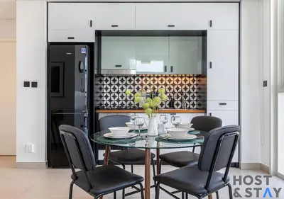 a dining room with a glass table and chairs at Minimalist 2BR in Dubai Hills in Dubai