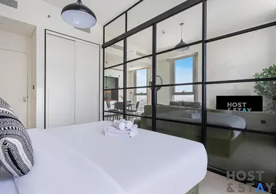 a bedroom with a white bed and a view of alost at Minimalist 2BR in Dubai Hills in Dubai