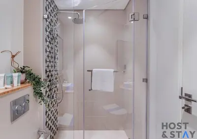 a bathroom with a shower with a glass door at Minimalist 2BR in Dubai Hills in Dubai