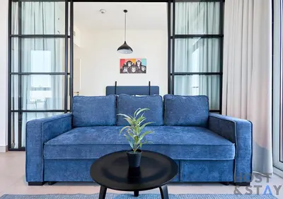 a blue couch in a living room with a table at Amazing 2BR in Collective 2 in Dubai