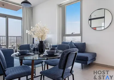 a dining room with a table and blue chairs at Amazing 2BR in Collective 2 in Dubai