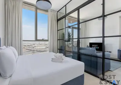 a bedroom with a white bed and a couch at Amazing 2BR in Collective 2 in Dubai