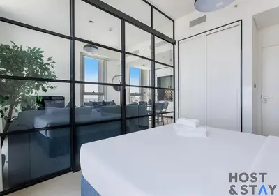 a room with glass walls and a couch and a table at Amazing 2BR in Collective 2 in Dubai