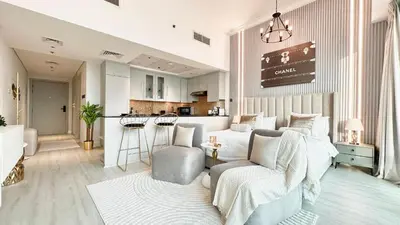 a living room with a couch and a kitchen at Luxury Family Studio Close to Dubai Mall and Burj Khalifa in Dubai