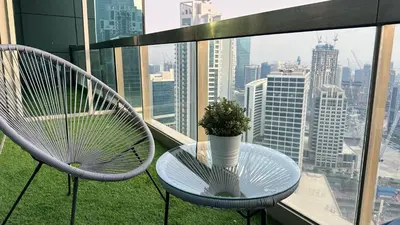 a table and chairs on a balcony with a view at Luxury Family Studio Close to Dubai Mall and Burj Khalifa in Dubai