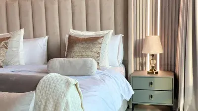 a bedroom with a bed and a side table with a lamp at Luxury Family Studio Close to Dubai Mall and Burj Khalifa in Dubai