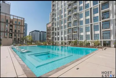 a large swimming pool in front of a tall building at Serene 1BR Getaway In Collective in Dubai