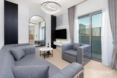 a living room with blue couches and a tv at Bespoke Holiday Homes - Sobha Creek Vistas Reserve in Dubai