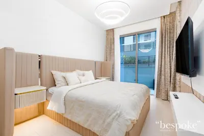a bedroom with a bed and a tv and a window at Bespoke Holiday Homes - Sobha Creek Vistas Reserve in Dubai