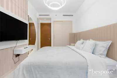 a bedroom with a large bed with a flat screen tv at Bespoke Holiday Homes - Sobha Creek Vistas Reserve in Dubai