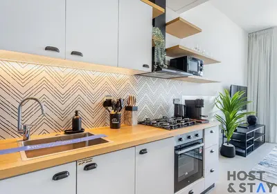 a kitchen with white cabinets and a wooden counter top at Stunning 1BR in Dubai Hills in Dubai
