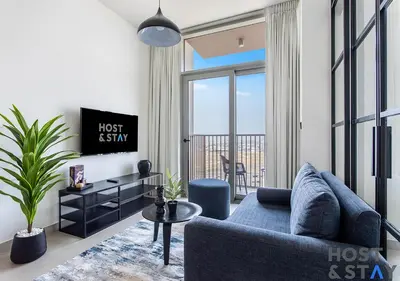 a living room with a blue couch and a tv at Stunning 1BR in Dubai Hills in Dubai