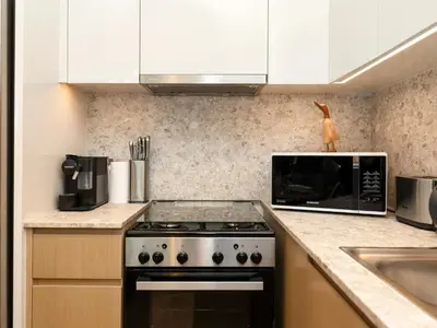 a kitchen with a stove and a microwave at The Burj Khalifa Suite Luxury 2-bed in Burj Royale in Dubai