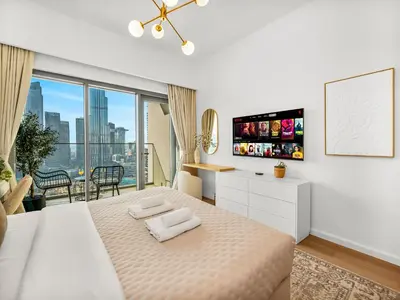 a white bedroom with a large bed and a large window at The Burj Khalifa Suite Luxury 2-bed in Burj Royale in Dubai