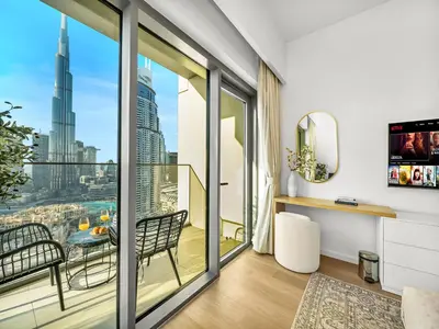 a room with a balcony with a view of the city at The Burj Khalifa Suite Luxury 2-bed in Burj Royale in Dubai