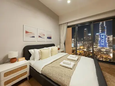 a bedroom with a large bed with a view of a city at The Burj Khalifa Suite Luxury 2-bed in Burj Royale in Dubai