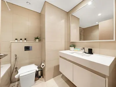 a bathroom with a sink and a toilet and a mirror at The Burj Khalifa Suite Luxury 2-bed in Burj Royale in Dubai