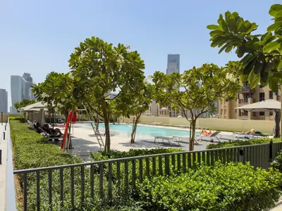 a swimming pool with trees and a fence at The Burj Khalifa Suite Luxury 2-bed in Burj Royale in Dubai