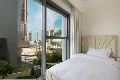 a bedroom with a white bed and a large window at 2 BR Dubai Luxury apartment Full Burj Views in Dubai