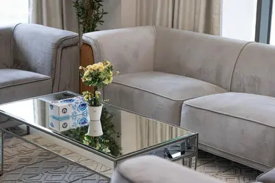 a living room with two couches and a coffee table with flowers at 2 BR Dubai Luxury apartment Full Burj Views in Dubai