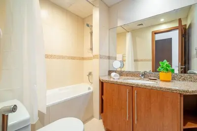a bathroom with a sink and a tub and a toilet at GuestReady - Home away from home in JLT in Dubai