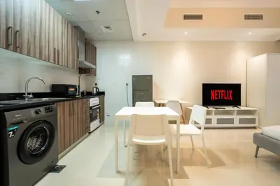 a kitchen with a table and a kitchen with a tv at AWS Holiday Homes - In the Heart of Downtown in Dubai