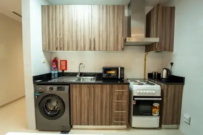 a kitchen with a washing machine and a sink at AWS Holiday Homes - In the Heart of Downtown in Dubai