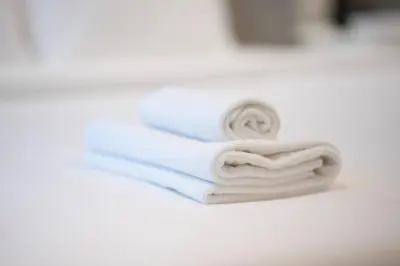 a stack of towels sitting on a bathroom sink at AWS Holiday Homes - In the Heart of Downtown in Dubai