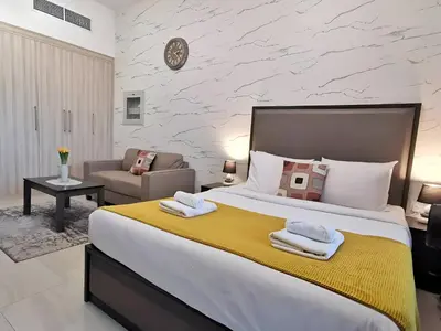 a bedroom with a large bed and a living room at Elite Residence - Business Bay in Dubai