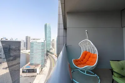 a hanging chair on a balcony with a view of a city at Elite Residence - Business Bay in Dubai