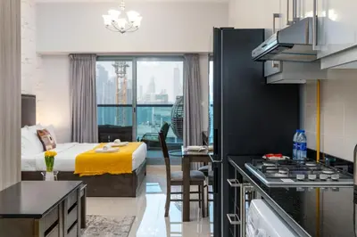 a hotel room with a bed and a kitchen with a stove at Elite Residence - Business Bay in Dubai