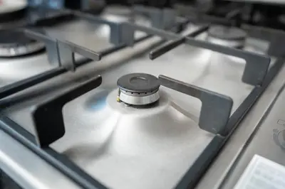 a close up of a gas stove top with a burner at Elite Residence - Business Bay in Dubai