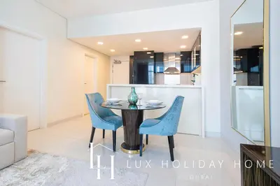 a dining room and kitchen with a table and chairs at LUX The Bays Edge Canal View Suite in Dubai