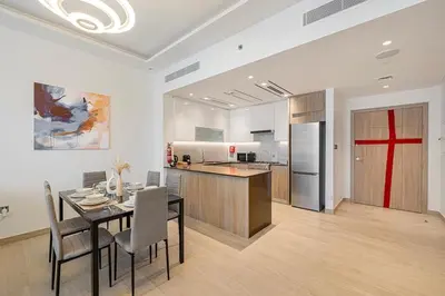 a kitchen and dining room with a table and chairs at Medore Brand New 1 and a half Bedroom apartment in Dubai