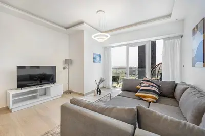 a living room with a couch and a flat screen tv at Medore Brand New 1 and a half Bedroom apartment in Dubai