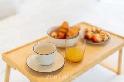 a table with a cup of coffee and a bowl of fruit at Me Do Re - Luxury Living 1 BR with Panoramic View - Zed Living in Dubai