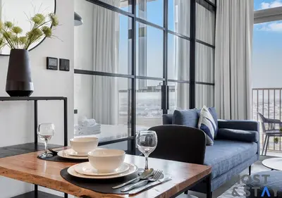 a living room with a table and a couch at Stunning 1bed In Dubai Hills in Dubai
