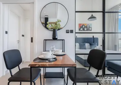 a dining room with a table and chairs and a bedroom at Stunning 1bed In Dubai Hills in Dubai